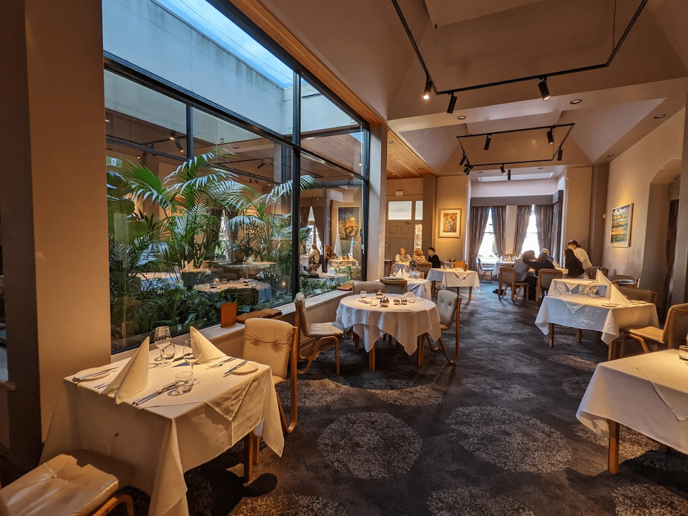 A restaurant dining area with tables and large window in Adelaide