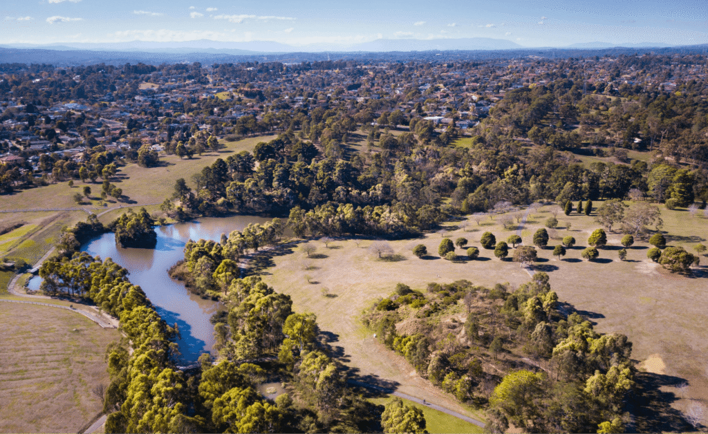 An aerial view of a river flowing through Manningham's lush green fields