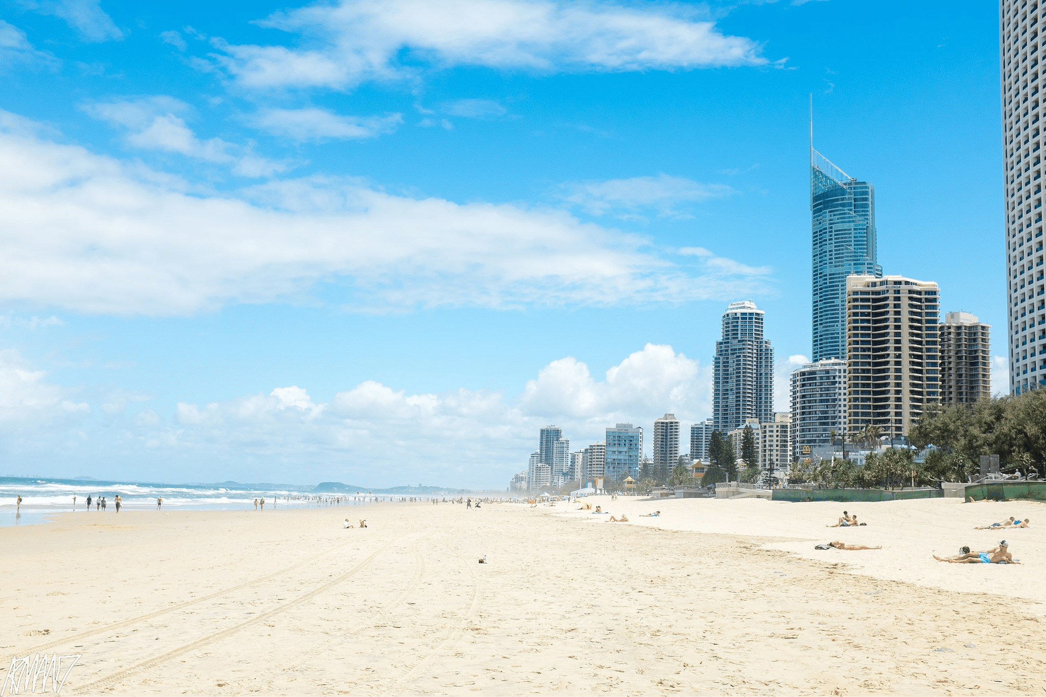 Busy beach scene with skyscrapers on Gold Coast