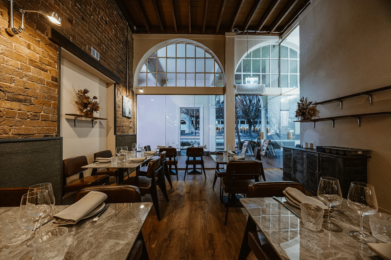 Interior of a Canberra restaurant with tables, chairs, and a brick wall
