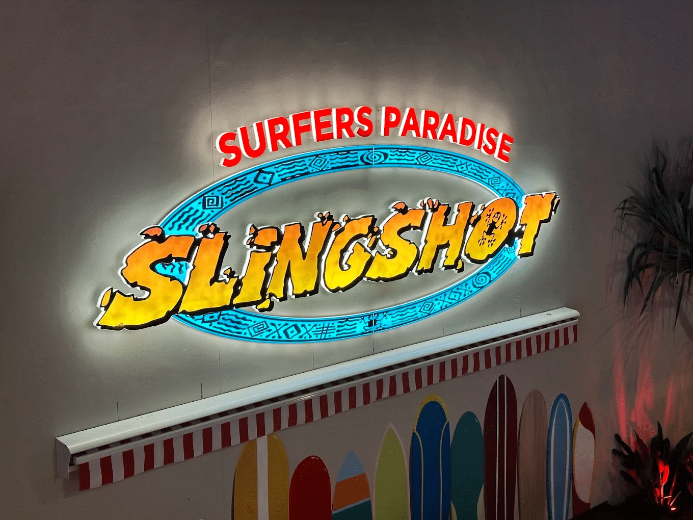 Neon slingshot sign on building in Gold Coast