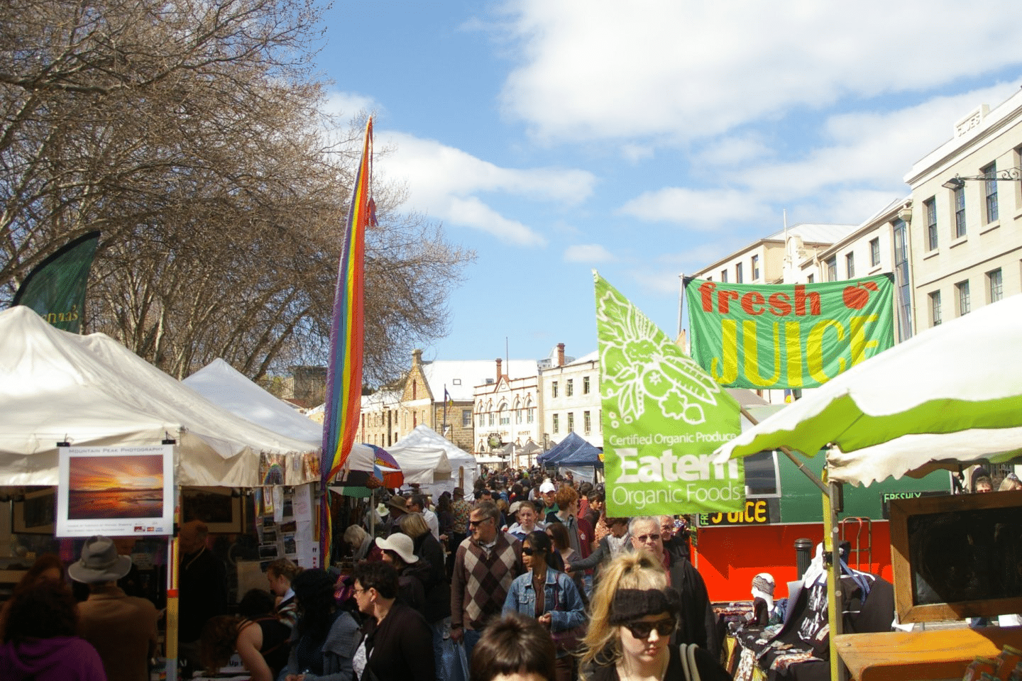 People exploring food stalls on a bustling Hobart street