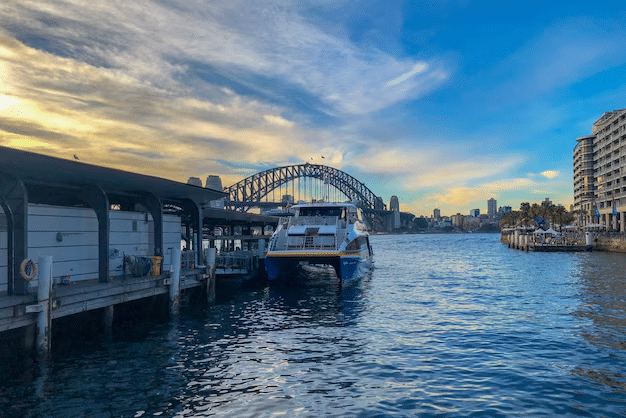 A boat docked at a pier with a bridge in Sydney, ideal for senior day trips