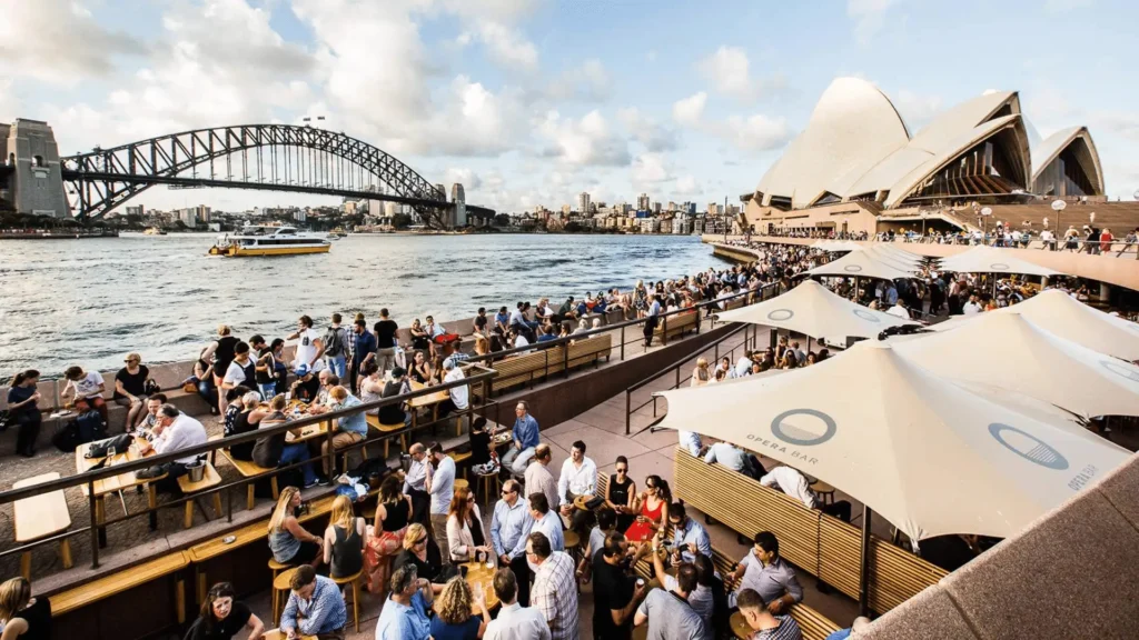A crowd of people by Sydney's riverbank