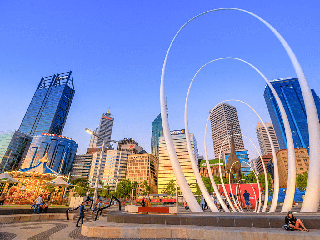 A group of people enjoying a day out in front of a sculpture in Perth
