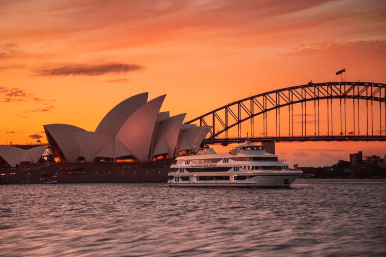 A large boat cruising near a bridge in Sydney Harbour