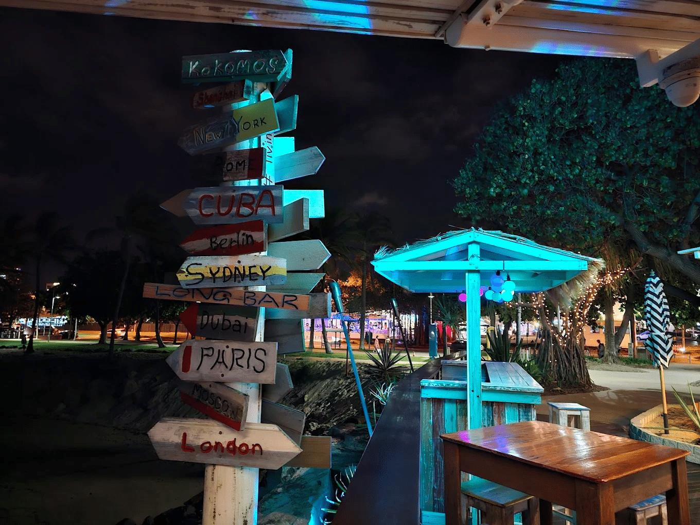 A variety of signs on a pole during Townsville food tour