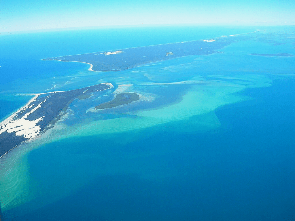 An aerial view of a lush island in the ocean near Brisbane