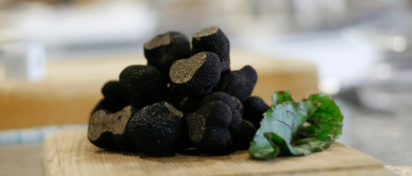 Black mushrooms on wooden cutting board for cooking tours in Launceston