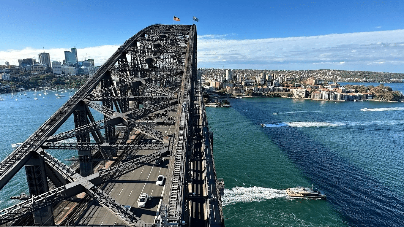 Boat crossing Sydney Harbour Bridge over water