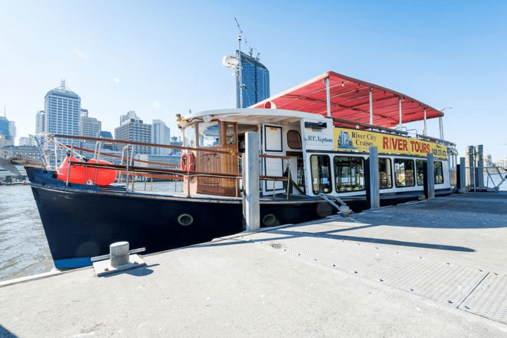 Boat docked at a pier with Brisbane city skyline