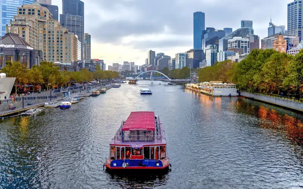 Boat on a river beside skyscrapers in Melbourne