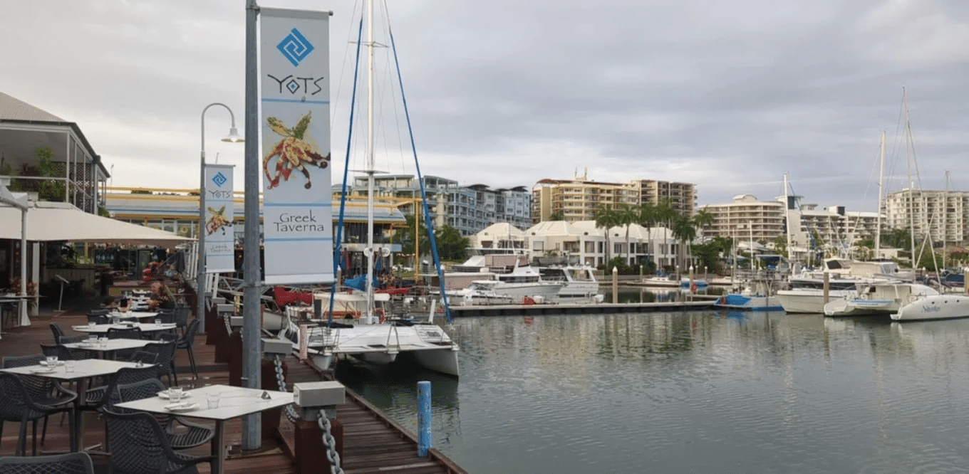 Boats docked at a marina near tall buildings in Darwin
