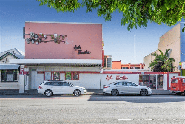Cars parked in front of a school building for a student excursion