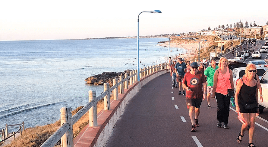 Church group walking along ocean road in Perth