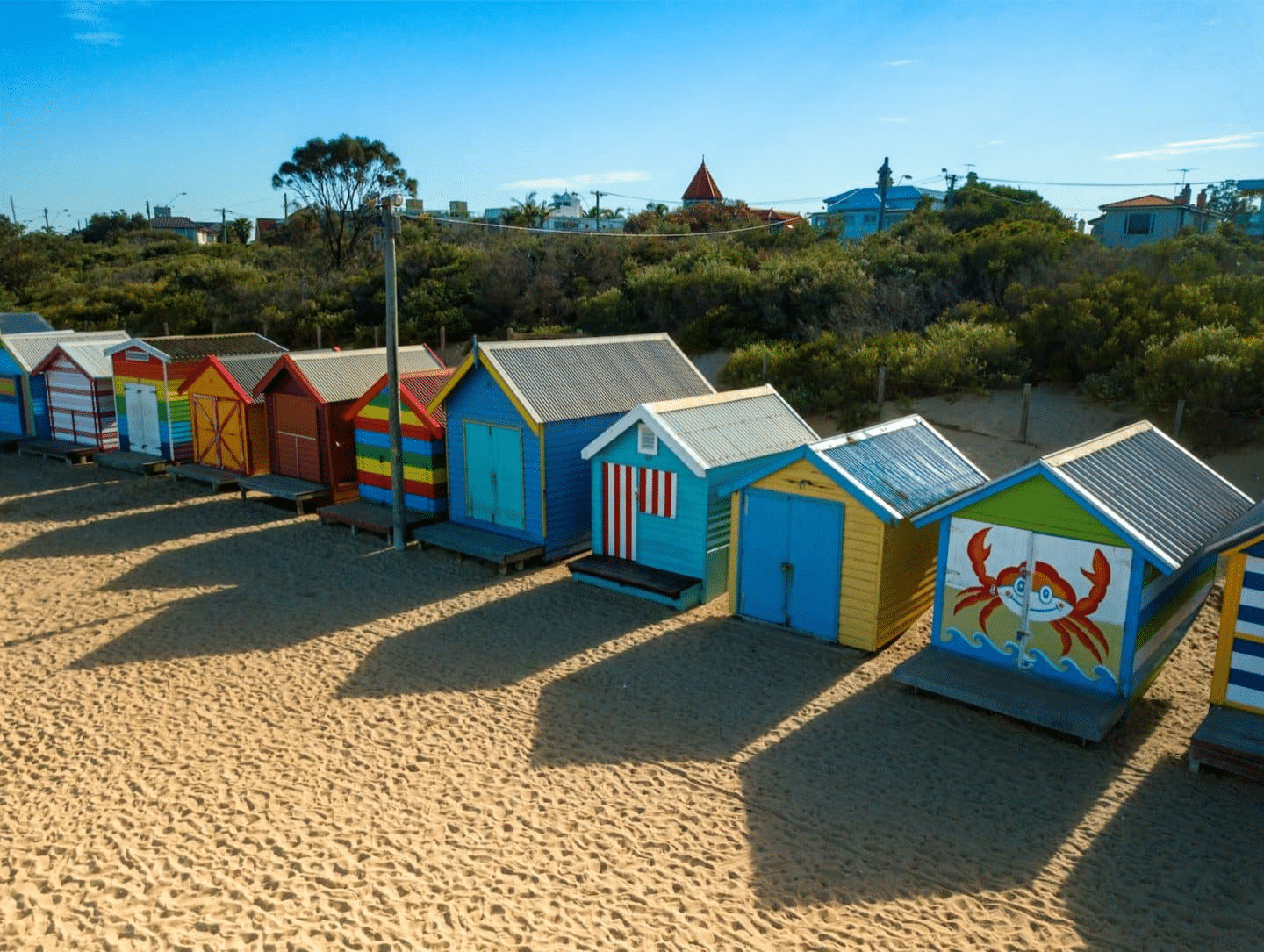 Colorful beach huts on sandy beach in Bayside Melbourne
