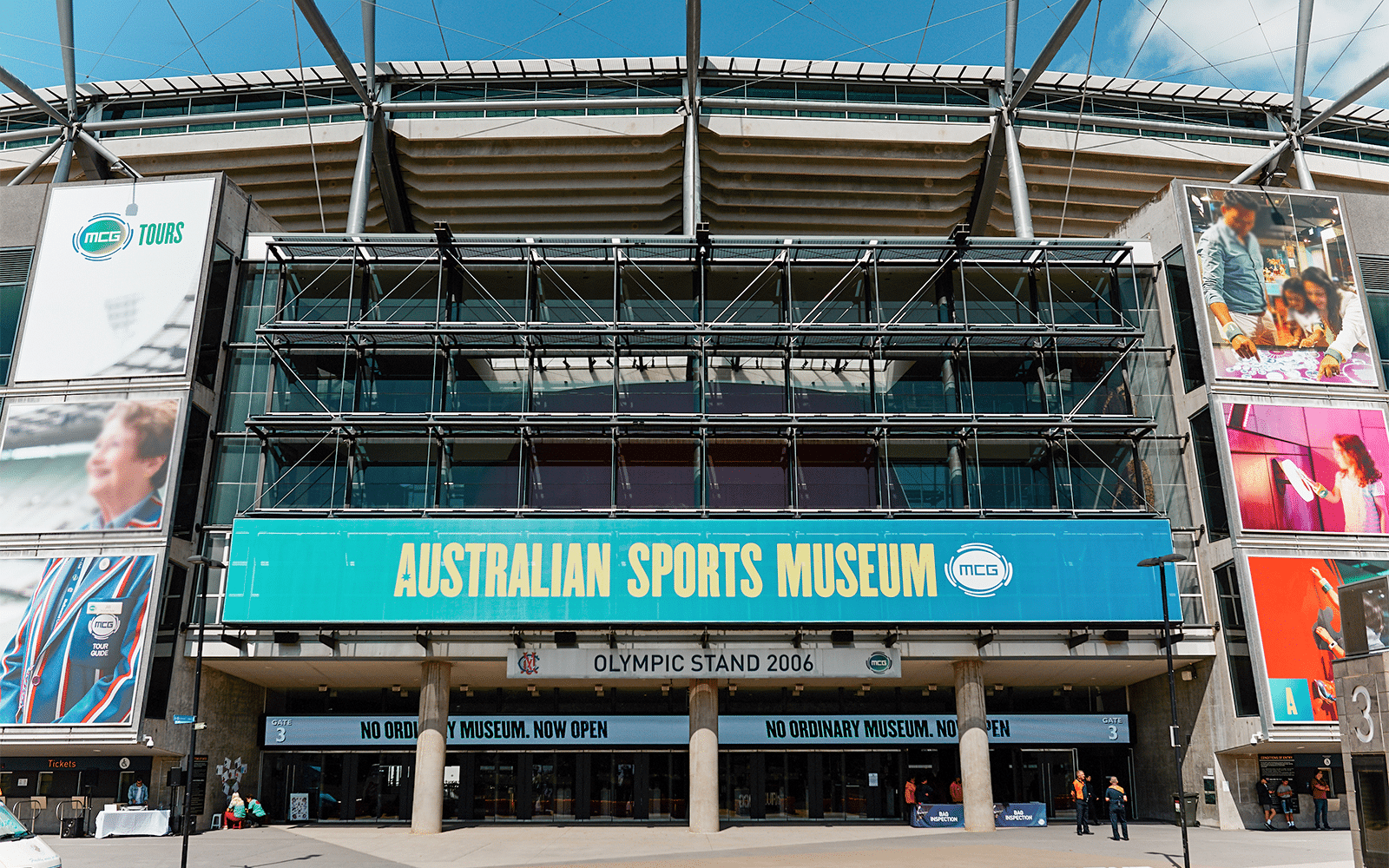 Exterior view of a sports stadium with numerous signs in Melbourne