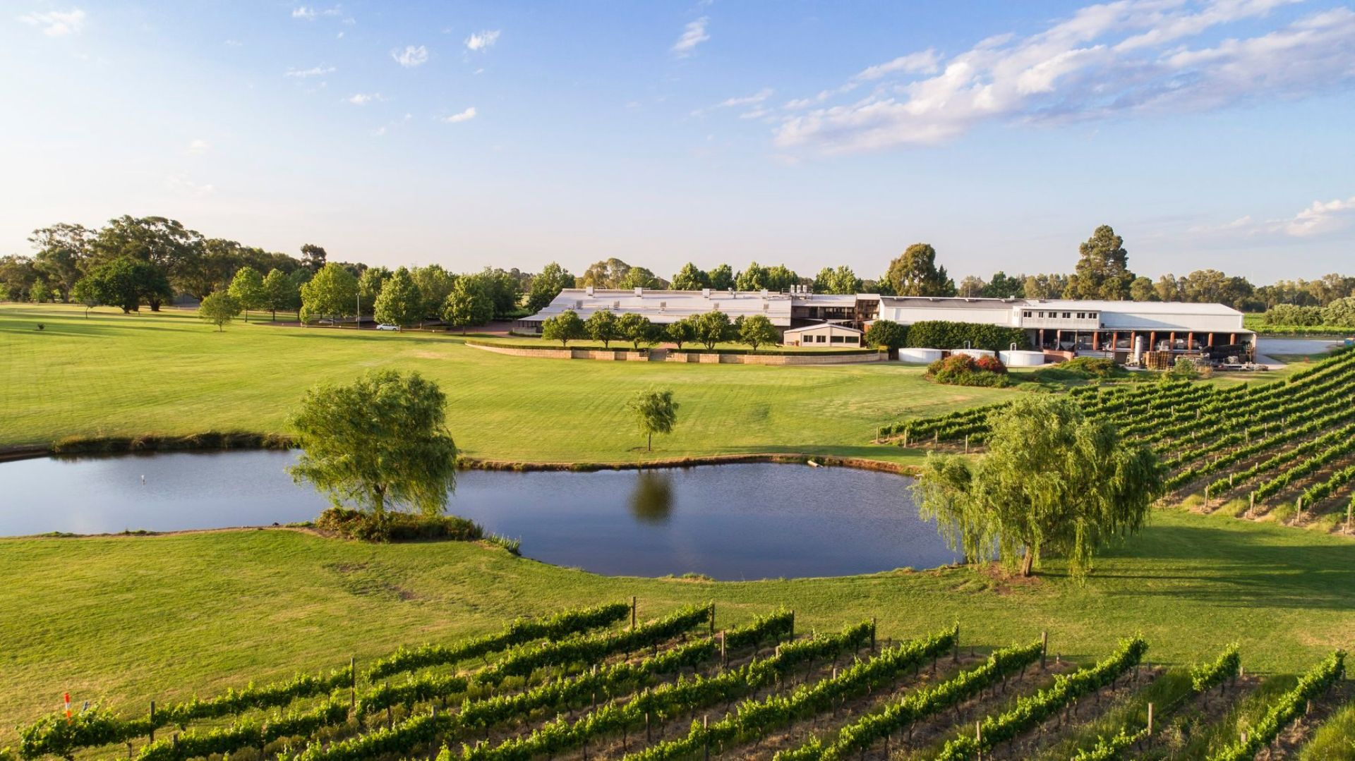 Field with pond and winery under clear sky in Perth