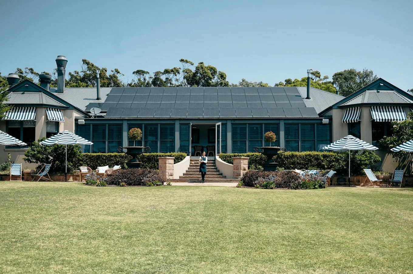 Large house with lawn chairs and umbrellas