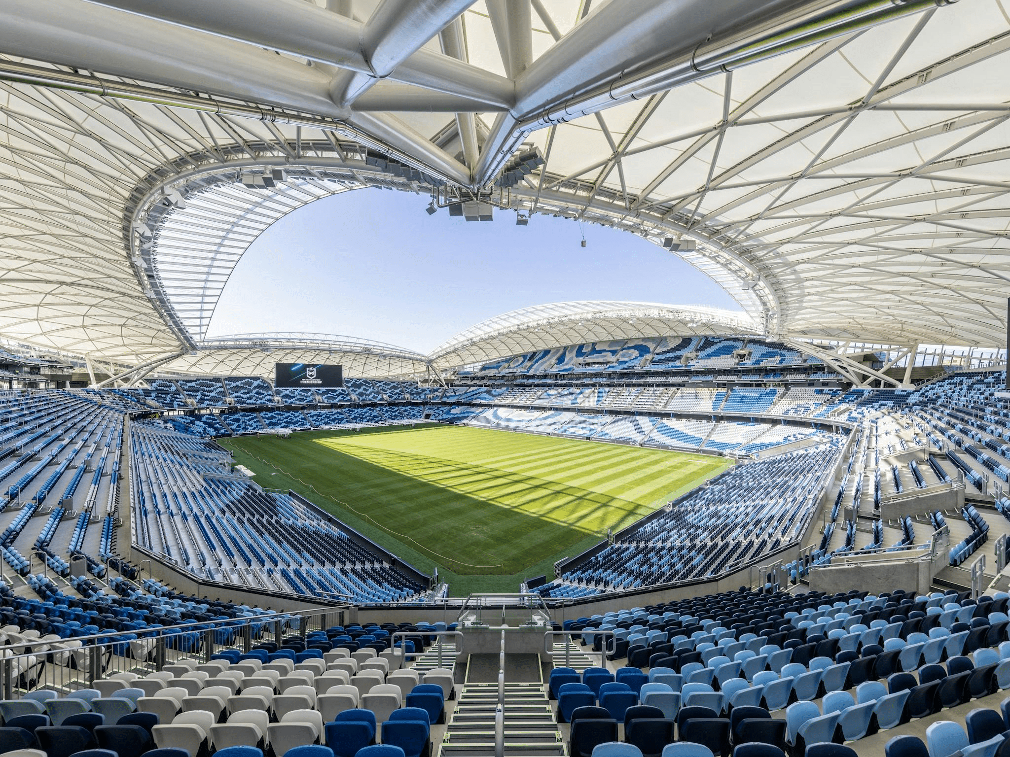 Large stadium in Sydney with blue seats and green field