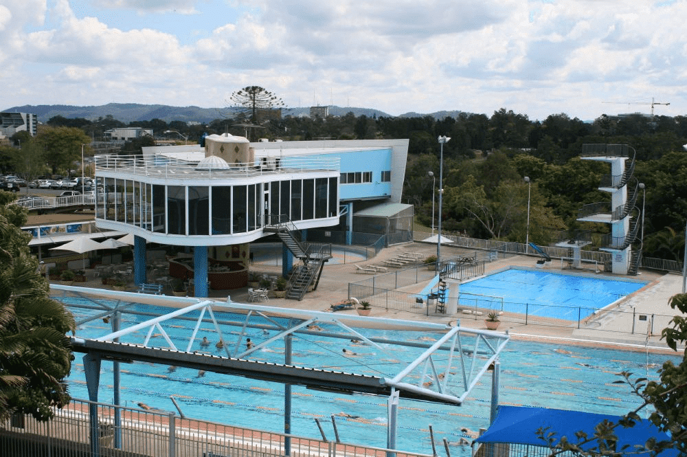 Large swimming pool in Brisbane surrounded by autumn trees and buildings