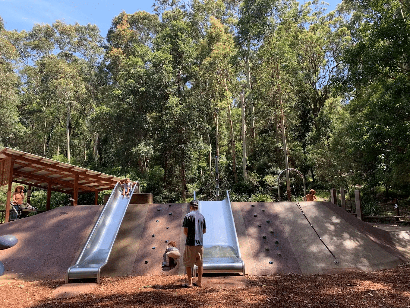 Man beside slide in Newcastle park during school excursion