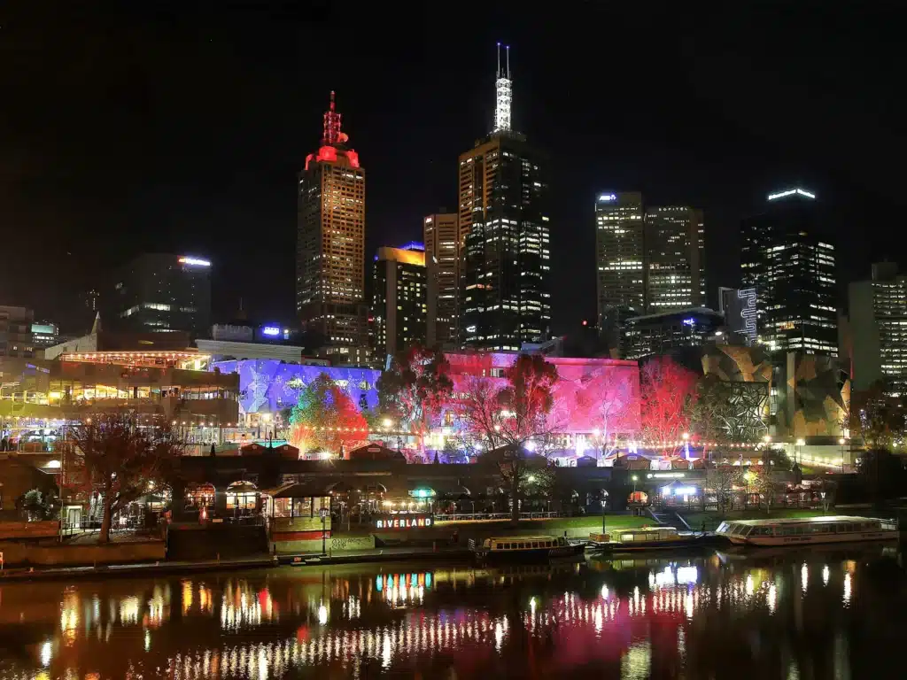 Melbourne city skyline at night with lights reflecting in water