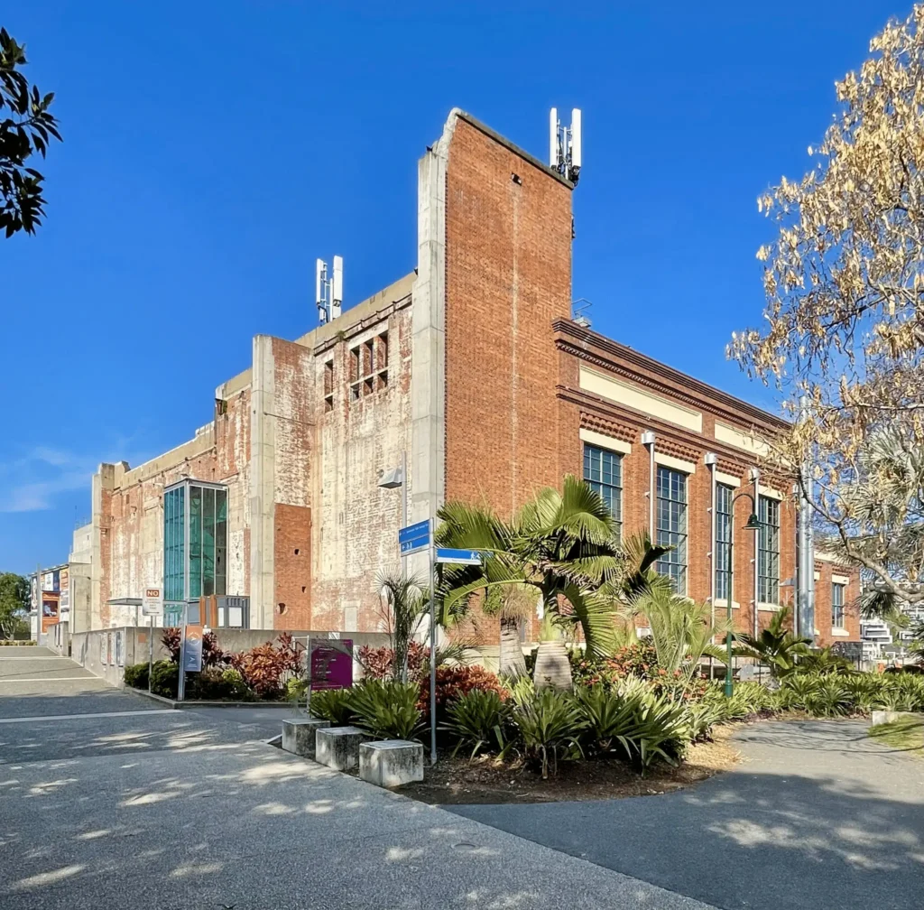 Modern Brisbane building surrounded by lush greenery