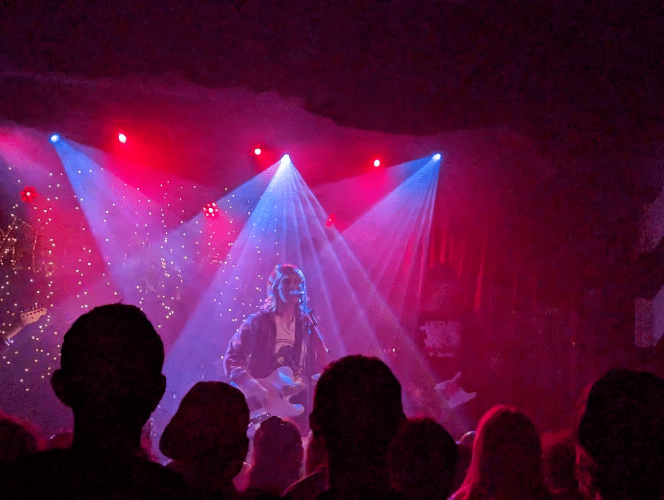 Musician performing on stage with guitar at Sydney music venue