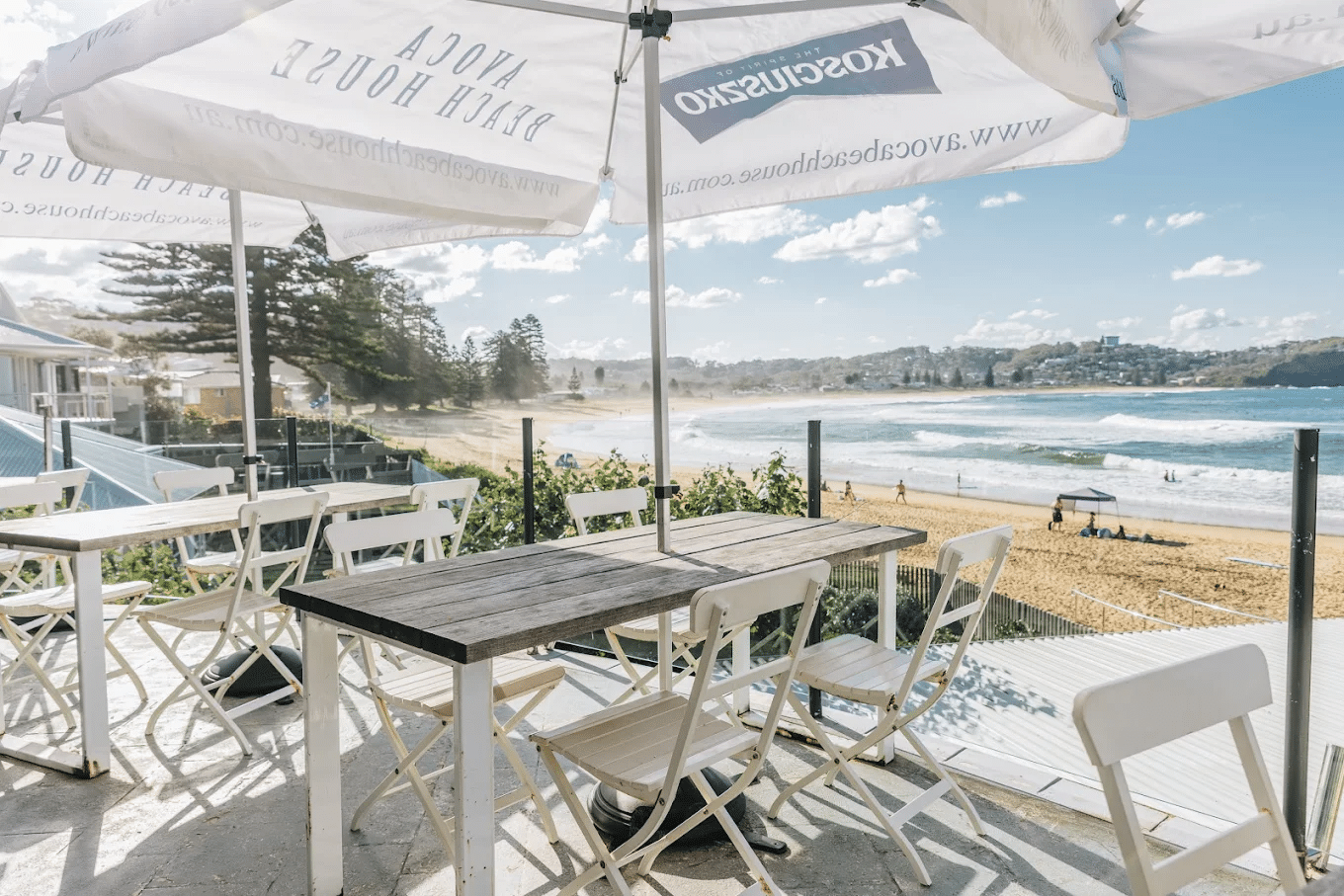 Oceanfront dining area with wooden table and umbrella