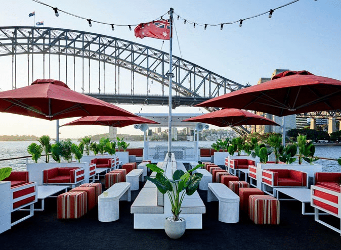 Outdoor dining area with red and white chairs at a Sydney Christmas party