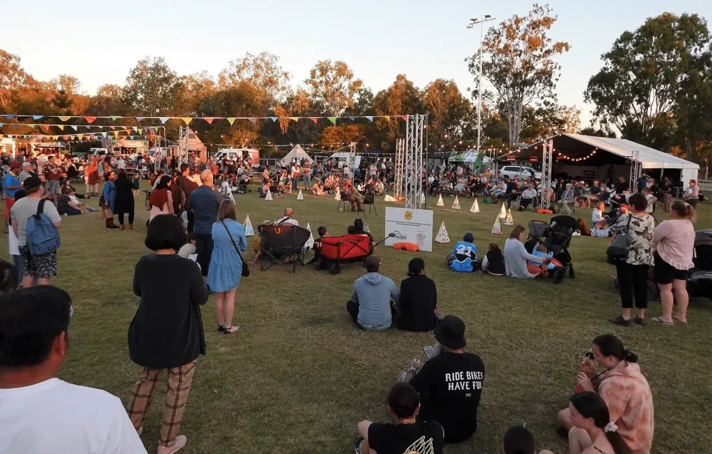 People enjoying a music event on a green field in Brisbane
