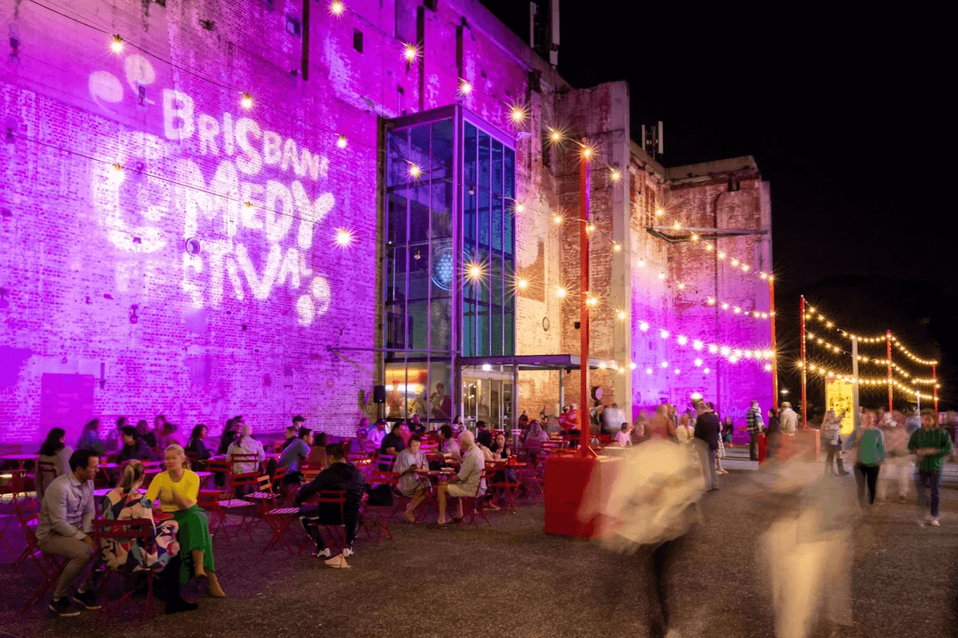 People seated around tables outside a building in Brisbane