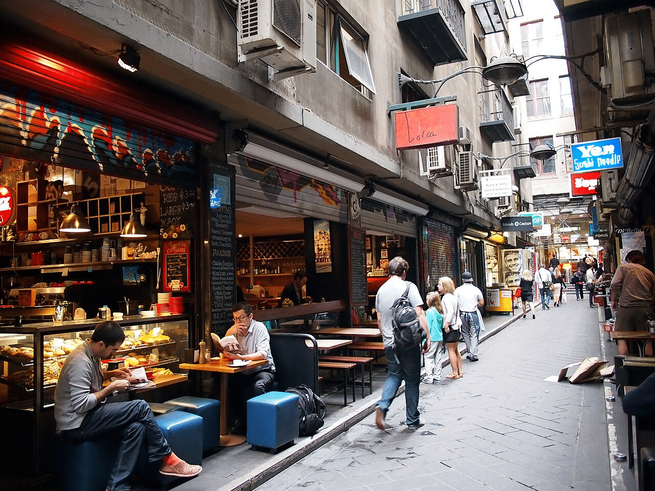 People sitting outside a Melbourne store on a food tour