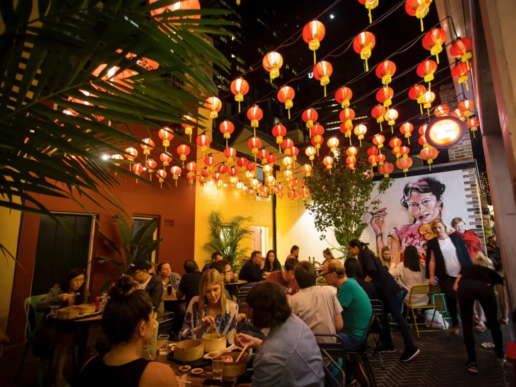 People socializing under red lanterns in Sydney