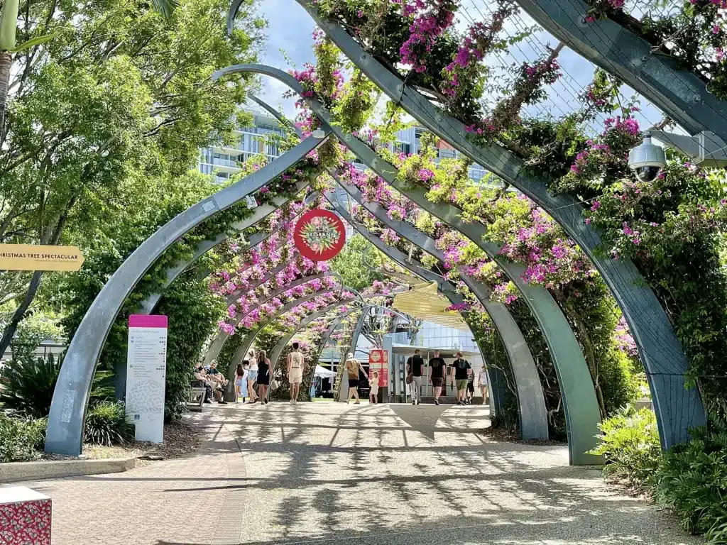 People strolling under flower-covered arch at South Bank Parklands, Brisbane
