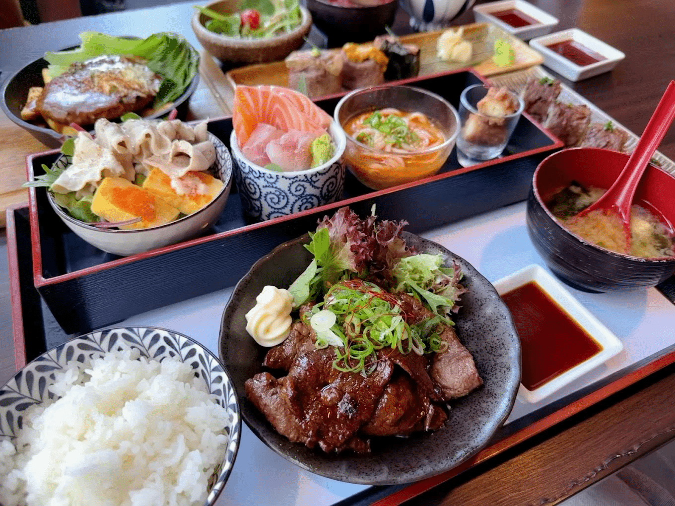 Plates of food and bowls of rice on a table during a Sydney food tour