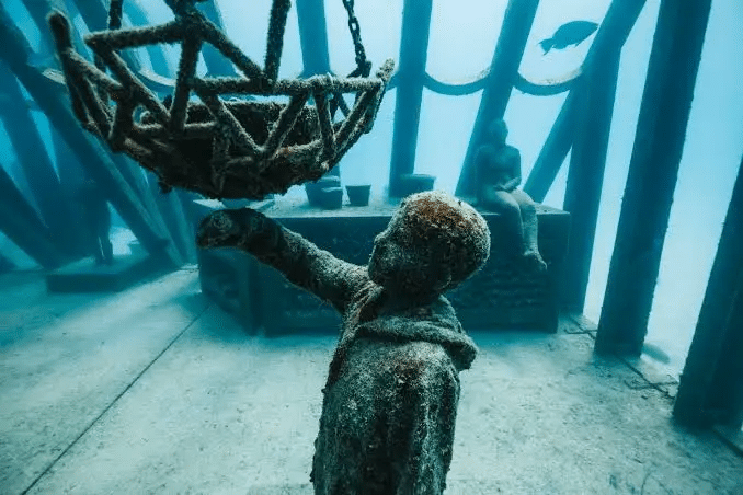 Statue of a person with basket in Townsville ocean
