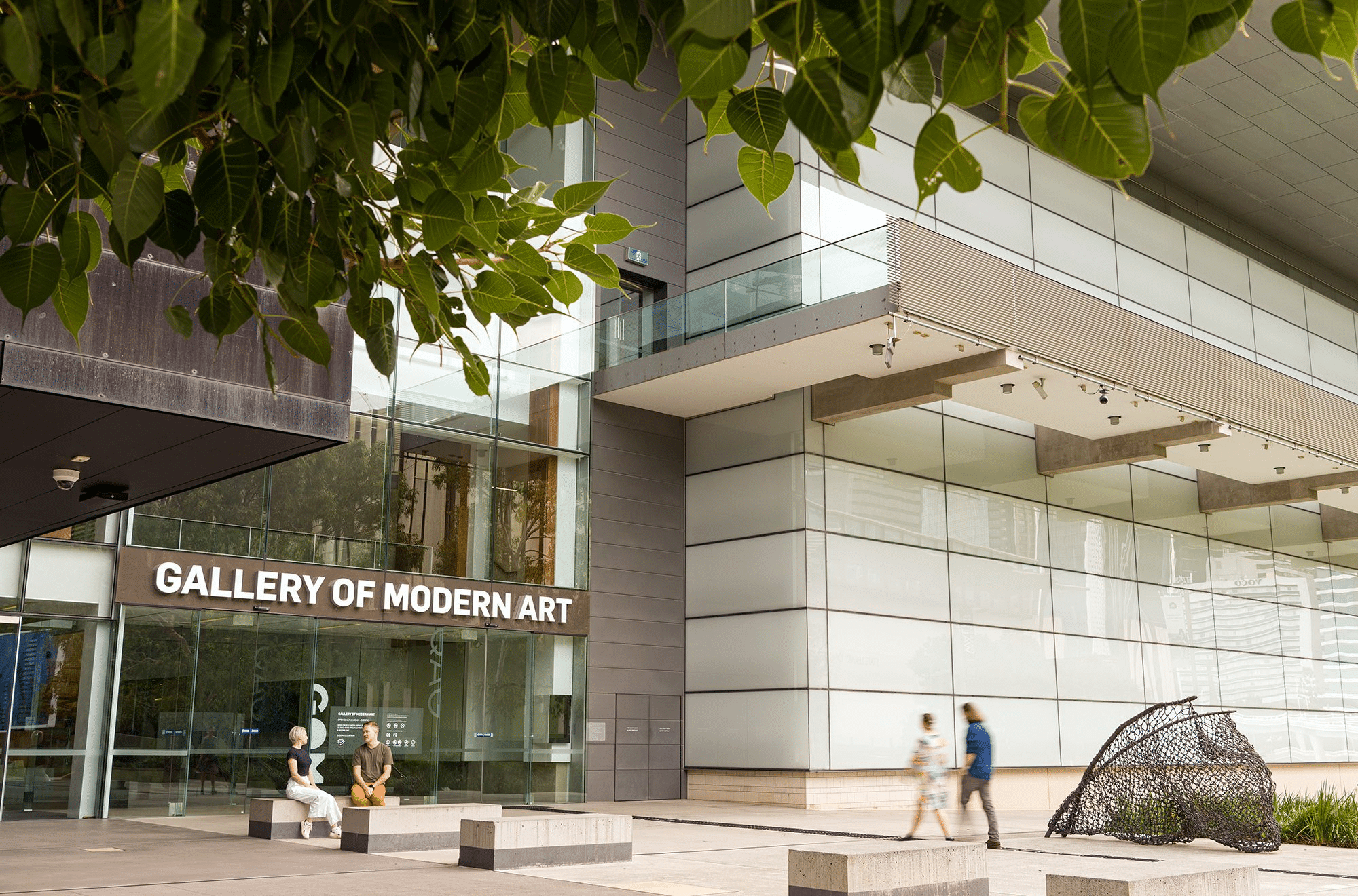 two people walking outside a modern art museum in brisbane