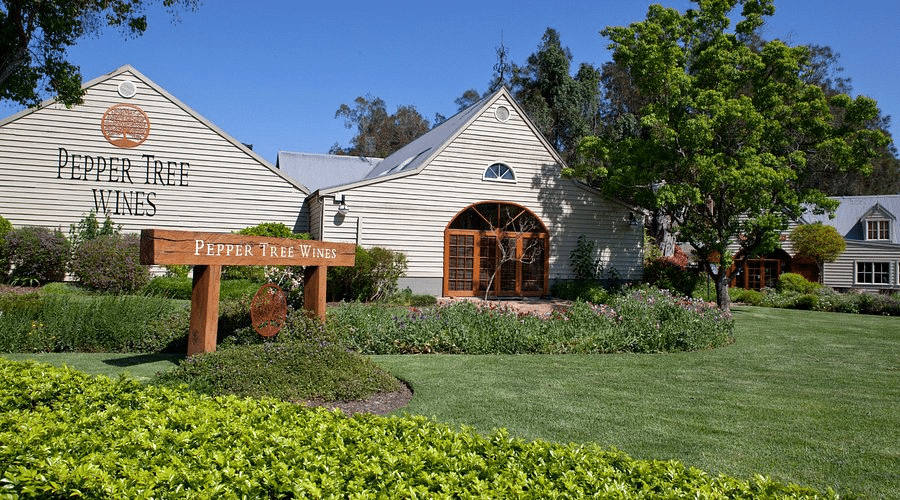 White building with Pepper Tree Wine wooden sign in front