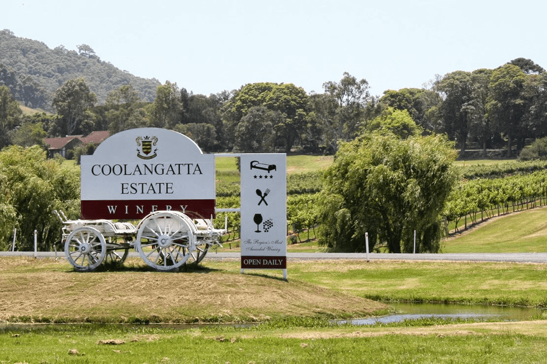 White horse drawn carriage in front of sign at Wollongong winery
