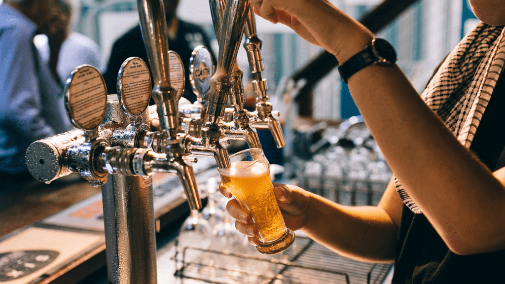 Woman pouring beer at bar during central coast food tour